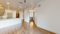 Located in Gilbert, Arizona, this well-appointed one-bedroom, one-bathroom unit offers a thoughtfully designed single-floor layout that maximizes its living space. The open-concept living and kitchen area is anchored by light-toned hardwood-style flooring and recessed lighting throughout, creating a bright and airy atmosphere.

The modern kitchen is a standout feature, showcasing taupe shaker-style cabinetry, white quartz countertops, a peninsula with an undermount sink, and a full suite of stainless steel appliances including a range, built-in microwave, and dishwasher. An adjacent pantry provides generous additional storage with built-in shelving.

The bedroom offers comfortable carpeting, a ceiling fan, and a window overlooking the outdoors, filling the room with natural light. Two doorways lead conveniently to both a dedicated closet and the full bathroom. The bathroom features a combined tub and shower with clean white tile surround, hardwood-style flooring, and chrome fixtures. The crisp white walls and clean finishes throughout the unit lend a fresh, move-in-ready feel to this efficiently designed Gilbert residence.