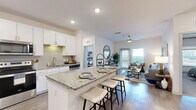 This thoughtfully designed 2-bedroom, 2-bathroom residence offers a functional and modern single-floor layout. The open-concept kitchen and living area serves as the heart of the home, featuring crisp white cabinetry, granite countertops, a tile backsplash, stainless steel appliances, and a central island with bar seating — ideal for both casual dining and entertaining. Wood-look flooring runs throughout the main living areas, complementing the bright, neutral color palette. The living room is generously proportioned, bathed in natural light from large windows, and includes a ceiling fan for added comfort.

The primary bedroom offers a comfortable retreat with plush carpet, a ceiling fan, and natural light from a well-positioned window, accompanied by a dedicated closet. The en-suite primary bathroom is a standout feature, boasting a dual-sink granite vanity with white cabinetry, a large mirror, and wood-look flooring. The second bedroom is equally well-appointed, also featuring carpet and a ceiling fan. A second full bathroom mirrors the same quality finishes, with a granite vanity and a shower.

Additional highlights include a dedicated in-unit laundry room equipped with a full-size washer and dryer, plus a hallway and two closets providing ample storage throughout.