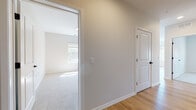 This well-appointed single-floor residence in Bloomfield, Connecticut offers a clean, modern aesthetic with thoughtfully selected finishes throughout. The open-concept living and dining area is anchored by light hardwood-style flooring that extends seamlessly through the main living spaces, creating a warm and cohesive feel. Large windows dressed with roller shades invite generous natural light, enhancing the bright, airy atmosphere.

The kitchen is a standout feature, equipped with stainless steel appliances including a refrigerator, electric range, and over-the-range microwave. Rich, dark wood cabinetry with matte black hardware contrasts smartly against crisp white countertops and a subway tile backsplash. A peninsula with a pendant light above provides additional counter space and a natural divide between the kitchen and dining area.

The bedrooms are carpeted for comfort and feature neutral wall tones, ample natural light from well-placed windows, and a tranquil ambiance suited for rest. A bathroom with clean white fixtures and hardwood-style flooring completes the space, finished with simple, functional details including a towel bar and accessible hardware. A hallway connects all areas fluidly, with additional doors providing access to closets or utility spaces. The overall design is contemporary, neutral, and move-in ready.