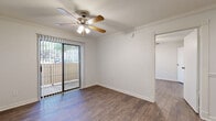 Located in Austin, TX (78752), this one-bedroom, one-bathroom unit offers a well-organized single-floor layout designed to maximize functionality. Hardwood-style flooring runs throughout the entire space, providing a cohesive and clean aesthetic from room to room.

The living room serves as the central gathering area and is enhanced by crown molding, a ceiling fan with integrated lighting, and a sliding glass door that opens to a private balcony — allowing natural light to filter in and providing outdoor views of the surrounding area.

The kitchen features dark cabinetry that contrasts neatly against light countertops and white appliances, including a refrigerator and range. A window above the sink brings in additional natural light, keeping the space bright and practical.

The bedroom is a comfortable, well-proportioned room with crown molding, a ceiling fan, and a large window fitted with blinds for light control. A dedicated closet provides convenient storage. The bathroom includes a full tub-shower combination with white tile surround, offering a clean and straightforward design.

Throughout the unit, neutral wall tones, consistent flooring, and classic trim details create a unified and livable atmosphere suited for everyday comfort in the heart of Austin.