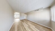 Located at 810 Lasalle Ave in Hampton, Virginia, this single-floor unit offers a clean, move-in-ready interior defined by consistent light-toned luxury vinyl plank flooring and a neutral color palette throughout. The open living areas are generously proportioned, with textured ceilings, crisp white baseboards, and multiple windows dressed with horizontal blinds that invite ample natural light into each room. The updated kitchen is a functional highlight, featuring white shaker-style cabinetry, light granite-style countertops, a stainless steel double-basin sink, and a full suite of appliances including an electric range with overhead microwave, a dishwasher, and a stainless steel refrigerator. A large window over the kitchen area frames outdoor greenery, adding a pleasant view while cooking. The bedrooms are well-sized and bright, each with windows offering exterior views and easy access to closet storage. A utility closet houses the water heater conveniently alongside additional storage space. The bathroom features a full tub-shower combination with clean white tile surround and chrome fixtures. Overall, the space presents a bright, well-maintained environment with practical updates suited for comfortable everyday living.