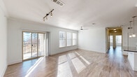 Located at 1750 FM-423 S in Little Elm, TX, this single-story home offers four bedrooms and four bathrooms across a generously sized floor plan. The open-concept living and kitchen area is bathed in natural light, courtesy of large windows and sliding glass doors that lead to a private balcony with views of the surrounding community. Wood-look tile flooring runs throughout, complementing the clean, bright aesthetic defined by white walls and crisp baseboards. A ceiling fan with integrated lighting and stylish track lighting enhance the living space's functionality and ambiance. The kitchen is a standout feature, boasting sleek dark granite countertops, a matching island with a stainless steel sink, tall white cabinetry, gray tile backsplash, and stainless steel appliances including a French door refrigerator. Each bedroom is well-proportioned and bright, with the primary bedroom offering generous closet space complete with built-in shelving and dual hanging rods. The bathrooms are finished with dark granite vanities, white cabinetry, and marble-style tile. One bathroom includes a glass-enclosed walk-in shower, while another features a soaking tub. The welcoming entrance and three closets add practical storage throughout this thoughtfully designed home.