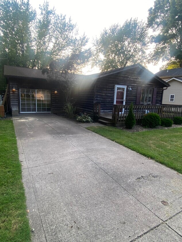 Front view with porch and access to connected garage turned living space - 986 Howell St