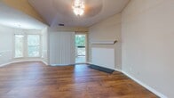 Located at 660 Halton Rd in Greenville, SC, this single-story home offers a thoughtfully designed layout with a warm, neutral color palette carried consistently throughout. The main living areas feature rich hardwood flooring that extends through the open-concept spaces, complemented by soaring vaulted ceilings that lend an airy, expansive feel. Chair rail molding adds a refined architectural detail to the dining and living areas, which are bathed in natural light through multiple windows dressed with horizontal and vertical blinds.

The kitchen is a standout feature, showcasing dark espresso cabinetry, granite countertops, stainless steel appliances, and a peninsula with a built-in sink — all flowing seamlessly toward a windowed dining area. An alternate kitchen configuration is also present, offering similar finishes with a more galley-style arrangement.

The bedrooms offer plush carpeting, large windows with wooded outdoor views, and a quiet, comfortable ambiance. The bathroom continues the cohesive design with dark-framed cabinetry, granite vanity surfaces, and contemporary lighting fixtures. Throughout the home, clean white baseboards, consistent warm-toned walls, and well-placed windows create a bright, welcoming environment that balances comfort and style.