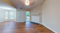 Located at 660 Halton Rd in Greenville, SC, this single-story home offers a thoughtfully designed layout with a warm, neutral color palette carried consistently throughout. The main living areas feature rich hardwood flooring that extends through the open-concept spaces, complemented by soaring vaulted ceilings that lend an airy, expansive feel. Chair rail molding adds a refined architectural detail to the dining and living areas, which are bathed in natural light through multiple windows dressed with horizontal and vertical blinds.

The kitchen is a standout feature, showcasing dark espresso cabinetry, granite countertops, stainless steel appliances, and a peninsula with a built-in sink — all flowing seamlessly toward a windowed dining area. An alternate kitchen configuration is also present, offering similar finishes with a more galley-style arrangement.

The bedrooms offer plush carpeting, large windows with wooded outdoor views, and a quiet, comfortable ambiance. The bathroom continues the cohesive design with dark-framed cabinetry, granite vanity surfaces, and contemporary lighting fixtures. Throughout the home, clean white baseboards, consistent warm-toned walls, and well-placed windows create a bright, welcoming environment that balances comfort and style.