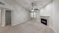 Located at Harbor Pointe in Sandy Springs, GA, this one-bedroom, one-bathroom residence offers a well-designed single-floor layout with a comfortable and functional living experience. The living room is a standout space, featuring vaulted ceilings, a ceiling fan with light fixture, and a tile-surround electric fireplace that serves as a warm focal point. Natural light filters in through slatted blinds, and plush carpeting throughout adds a cozy feel to the living and bedroom areas. The kitchen is efficiently laid out in a galley style, outfitted with white cabinetry, granite-look countertops, a stainless steel refrigerator and range, and wood-look flooring that extends into the adjacent spaces. The bedroom is a generously sized retreat with a window overlooking lush greenery, soft carpet underfoot, and direct access to a dedicated closet. The bathroom is clean and well-appointed, featuring a tub/shower combo with white tile surround, a white vanity with granite-look countertops, and wood-look flooring. Neutral gray tones throughout the space create a cohesive, move-in ready aesthetic that is both versatile and inviting.