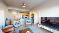 Located at 408 S Nevada Ave in the heart of Colorado Springs, CO, this well-appointed 2-bedroom, 2-bathroom residence delivers a thoughtfully designed open-concept layout across a single floor. Light wood-style flooring flows throughout, tying the living spaces together seamlessly.

The combined kitchen and living area serves as the social hub of the home. The kitchen features warm maple cabinetry, stainless steel appliances including a refrigerator, range, and microwave, complemented by grey countertops and a peninsula with bar seating — ideal for casual dining. Pendant lighting and recessed fixtures illuminate the space effectively. The adjacent living room benefits from large floor-to-ceiling sliding glass doors that open to a private balcony, bathing the area in natural light and offering views of the surrounding downtown Colorado Springs skyline. A ceiling fan adds to the room's comfort.

The generously sized primary bedroom includes a window for natural light and ample space for a full furniture suite, while the second bedroom provides flexible use. Each bathroom is clean and functional, with one featuring a full tub-shower combination, wood-toned vanity cabinetry, and neutral grey walls. Two dedicated closets provide practical storage throughout. The overall ambiance is modern, bright, and urban.