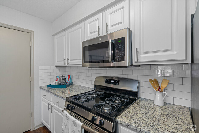 White Shaker Cabinetry with Designer Hardware and Tile Backsplashes - The Terraces at Lake Mary