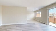 Located in Los Angeles' 90008 neighborhood, Unit 14 at 3910 Coco Ave is a well-appointed 2-bedroom, 1-bathroom unit spread across a single floor. The living room is a standout feature, bathed in natural light through a large sliding glass door that opens to a private outdoor balcony area, offering pleasant neighborhood views. Light gray wood-style flooring flows throughout the living spaces and bedrooms, contributing to a clean, cohesive aesthetic. The kitchen features a galley-style layout with white shaker cabinetry, dark countertops, stainless steel appliances including a refrigerator and dishwasher, and light tile flooring, offering an efficient and stylish space for meal preparation. Both bedrooms are well-sized, each equipped with ceiling fans, windows with blinds for natural light and privacy, and sliding-door closets providing ample storage. The primary bedroom offers a comfortable footprint suited for a full bedroom suite. The bathroom is finished with marble-style tile surrounding the shower/tub combo, white vanity cabinetry, and a dark countertop, echoing the design language found throughout the unit. A connecting hallway ties all rooms together in a functional and organized floor plan.