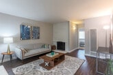 Located at 902 W Remington Dr in Sunnyvale, CA, this single-story 2-bedroom, 1-bathroom home offers a thoughtfully arranged layout with a warm, inviting ambiance throughout. The living room serves as the heart of the home, showcasing a striking white-painted brick fireplace, rich dark hardwood floors, and ample natural light streaming through large windows fitted with blinds. The space flows seamlessly into a dedicated dining area, which features its own window and ceiling fan, making it a bright and comfortable spot for meals. The kitchen is outfitted with white cabinetry, light stone countertops, a stainless steel sink, and a pass-through mirror that adds depth and openness to the space. Both bedrooms are carpeted and well-sized, with neutral tones and windows that bring in natural light. The primary bedroom offers comfortable proportions with generous closet access. The home includes four closets in total, providing ample storage throughout. The full bathroom features a clean, all-white tiled tub and shower combination with chrome fixtures. A connecting hallway ties the layout together efficiently. The overall design is clean, neutral, and functional — well-suited for comfortable living in the heart of Silicon Valley.