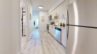 This contemporary 570 square foot apartment maximizes space with its thoughtful design. The open-concept layout seamlessly blends the kitchen, living, and dining areas, creating a sense of spaciousness. The kitchen showcases sleek white cabinetry, stainless steel appliances, and a functional layout perfect for culinary enthusiasts.

The bedroom, spanning 90 square feet, offers a tranquil retreat with large windows providing ample natural light and city views. The bathroom features modern fixtures and a tub-shower combination, maintaining a clean and minimalist aesthetic.

A standout feature is the private balcony, accessible through sliding glass doors, offering an outdoor extension of the living space. The apartment boasts light wood-look flooring throughout, enhancing the bright and airy ambiance.

In-suite laundry adds convenience, while thoughtful touches like contemporary light fixtures and carefully chosen artwork contribute to the overall modern feel. The neutral color palette provides a versatile backdrop for personalization.

Located at 1475 Whites Rd, Pickering, this apartment combines style, functionality, and location, making it an ideal choice for those seeking a compact yet well-appointed living space.