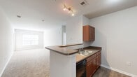Located at 1034 Finnwood Dr in Whitsett, NC, this single-floor, 2-bedroom, 2-bathroom home offers a well-organized layout designed for comfortable everyday living. The open-concept kitchen flows seamlessly into the combined dining and living area, which is bathed in natural light from a large front-facing window and finished with plush wall-to-wall carpeting. The kitchen is well-appointed with warm wood-toned cabinetry, dark countertops, a double-basin sink, and a full suite of black appliances including a refrigerator, dishwasher, and range. A peninsula counter provides additional workspace and a natural divider between the kitchen and living space. Wood-look flooring runs through the kitchen and wet areas, adding a clean contrast to the carpeted rooms. Both bedrooms are generously sized, with soft carpeting, ceiling fans, and ample closet space — six closets are distributed throughout the home. The bathrooms are finished with wood-look tile flooring, warm wood vanities, and a tub-shower combination. A dedicated laundry room with washer/dryer hookups adds everyday convenience. The home's neutral color palette and clean lines create a bright, move-in-ready atmosphere throughout.