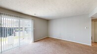 This single-floor, 1-bedroom, 1-bathroom unit in Indianapolis, IN (46260) offers a practical and comfortable layout designed to maximize every square foot of its compact footprint. The living room is a welcoming, open space finished with warm beige carpeting and neutral-toned walls, featuring a sliding glass door with vertical blinds that invites natural light and provides outdoor views. A textured ceiling adds a classic residential touch throughout the main living areas. The bedroom is a well-proportioned room with plush carpeting, a window dressed with vertical blinds for natural light and privacy, and a closet for storage. The kitchen features light wood-style vinyl flooring, white cabinetry, light countertops, and black appliances including a range and refrigerator, along with a built-in vent hood and open shelving. The full bathroom is finished with wood-style flooring, a white vanity with a marble-patterned countertop, a mirrored medicine cabinet, and a tub-shower combination with tile surround. Neutral paint tones and consistent finishes throughout lend the space a clean, cohesive aesthetic, making it a functional and move-in ready home in the Indianapolis area.