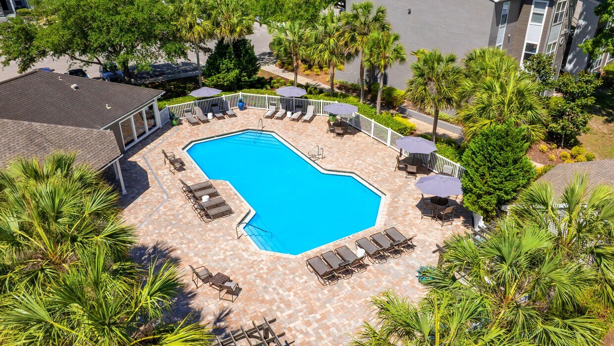 Una impresionante vista aérea de la espectacular piscina de The Enclave en Huntington Woods, completa con una amplia terraza para tomar sol, sillas para descansar y asientos a la sombra para disfrutar de un día perfecto bajo el sol de Florida. - The Enclave at Huntington Woods