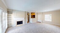 This 1-bedroom, 1-bathroom unit at Platinum in Houston, TX offers a well-designed single-floor layout with a warm, neutral color palette throughout. The spacious living area is a standout feature, centered around a classic white-mantled fireplace with tile surround and framed by crown molding along the ceiling. Plush carpet flooring extends throughout the living and bedroom spaces, adding comfort underfoot. French doors in the living area flood the room with natural light and provide direct access to an outdoor area, while additional windows with blinds enhance the bright, airy ambiance.

The kitchen is positioned in an open pass-through arrangement, featuring dark cabinetry, granite countertops, stainless steel appliances, and wood-look flooring. A pantry with bi-fold doors provides ample storage. The bedroom is generously sized, equipped with a ceiling fan, large windows overlooking the outdoors, and a sliding mirrored closet for convenient storage.

The bathroom includes a tiled shower-tub combination, a granite-topped vanity with dark cabinetry, and wood-look flooring that complements the kitchen. The overall layout is practical and cohesive, making this unit a comfortable and functional residence in the heart of Houston.