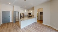 Located at 1630 Lewis Creek Rd in Wilmington, NC, this single-story residence offers a well-designed, open layout with modern finishes throughout. The exterior features classic brick construction with a covered entry storage closet and a paneled front door, providing a clean and functional arrival experience.

The heart of the home is an open-concept kitchen equipped with white shaker cabinetry, granite countertops, a tile backsplash, and stainless steel appliances including a refrigerator with ice maker, electric range, microwave, and dishwasher. A central island with an undermount sink and pendant lighting above serves as both a workspace and gathering point, flowing seamlessly into the adjacent living and dining areas.

Living spaces feature light hardwood-style flooring, ceiling fans, and neutral walls that lend a bright, airy atmosphere. A door with transom window and adjacent full-size window allows natural light into what appears to be a flexible dining or bonus room.

Bedrooms are generously proportioned with ceiling fans and access to walk-in closets with built-in shelving. Bathrooms are finished with granite vanity tops, wood-framed mirrors, and tub-shower combinations with brushed nickel hardware and built-in shelving. A dedicated laundry room accommodates a full-size washer and dryer with overhead wire shelving for added storage.