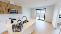 Located on the seventh floor at 611 Davenport Road in Waterloo, Ontario, this efficiently designed one-bedroom, one-bathroom unit offers a well-planned layout across a single floor. The space features light-toned hardwood flooring throughout, crisp white walls, and recessed lighting that contribute to a clean, modern aesthetic.

The kitchen serves as a functional centerpiece, featuring warm wood-finish upper cabinetry with matte black hardware, white lower cabinets, a light stone-finish countertop with a peninsula, and a full suite of stainless steel appliances including a refrigerator, stove, and over-the-range microwave. A classic white subway tile backsplash adds a polished touch. The entry is marked by a solid wood door with a smart lock and black hardware.

The bedroom is a cozy, well-proportioned space finished with the same light hardwood flooring and neutral white walls. A large picture window with a navy-accented roller blind frames an elevated view of the Waterloo skyline and surrounding landscape, flooding the room with natural light.

The bathroom is finished in a clean, minimalist style, featuring a full soaker tub with polished chrome fixtures set against smooth white surround panels. The overall unit offers a practical and modern living environment suited to contemporary urban living.
