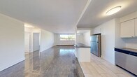 Located at 2570 Kingston Rd in Toronto's Kingston Road corridor, this one-bedroom, one-bathroom unit offers a well-organized layout across a single floor. The combined kitchen and living area forms the heart of the space, where a modern kitchen stands out with white shaker cabinetry, a subway tile backsplash, dark countertops, stainless steel appliances including a fridge, stove, and dishwasher, and light tile flooring. A peninsula counter provides additional workspace and a natural transition into the living area, which features classic parquet wood flooring that continues throughout the unit. Large windows in the living room invite generous natural light and offer views of the surrounding neighbourhood. The spacious primary bedroom is a comfortable retreat, also finished with polished parquet flooring, a baseboard heating unit, a bright window, and a full-width mirrored sliding closet that enhances the sense of space. The four-piece bathroom is cleanly finished with subway tile surrounding the bathtub and stone-look tile flooring. A private balcony extends the living space outdoors, overlooking a landscaped parking area framed by mature trees under open skies.