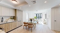 Located at 2971 Shell Road in Brooklyn's Coney Island neighborhood, this thoughtfully designed three-bedroom, two-bathroom residence showcases a clean, modern aesthetic with premium finishes throughout its single-floor layout. The open-plan kitchen and living area serves as the heart of the home, where light wood-tone cabinetry, a striking marble-look backsplash, sleek countertops, and stainless steel appliances combine to create a highly functional and visually refined kitchen. A glass-top dining table flows naturally into the sunlit living room, which is anchored by floor-to-ceiling black-framed windows that invite abundant natural light and offer open views of the surrounding neighborhood. Light hardwood flooring runs seamlessly throughout, reinforcing the home's bright, airy atmosphere. Both bathrooms are finished with elegant marble-look wall and floor tile, warm brass and gold fixtures, LED-lit vanity mirrors, and soaking tubs, lending a spa-like quality to each space. The primary bedroom provides a serene retreat with soft tones, large windows with exterior views, and generous proportions. The additional bedrooms are equally well-appointed, each featuring natural light and modern finishes. Recessed lighting and tray ceiling details add architectural interest, while the cohesive neutral palette creates a calm, sophisticated ambiance throughout this well-appointed Brooklyn residence.