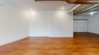 Located at 305 N 3rd St in Burlington, Iowa, this single-floor unit offers a well-organized layout that makes efficient use of its compact footprint. Warm-toned hardwood-style flooring runs throughout the entire space, creating a cohesive and inviting atmosphere.

The open-concept kitchen and living area serves as the heart of the unit. The kitchen is outfitted with a full suite of stainless steel appliances, including a refrigerator, electric range, dishwasher, and microwave, all complemented by crisp white cabinetry, light countertops, and a built-in desk or prep area. Exposed ductwork adds an urban, industrial character to the space. The living area is bright and open, with recessed lighting and a glass-paneled entry door that allows natural light to flow in.

A separate bedroom provides a quiet retreat, featuring a ceiling fan, a large sliding-door closet, and clean white walls. The bathroom is thoughtfully designed with accessibility in mind, including grab bars and hardwood-style flooring that mirrors the rest of the unit. The dedicated laundry room houses a full-size Whirlpool front-load washer and dryer set, adding everyday convenience to this functional and well-appointed space.