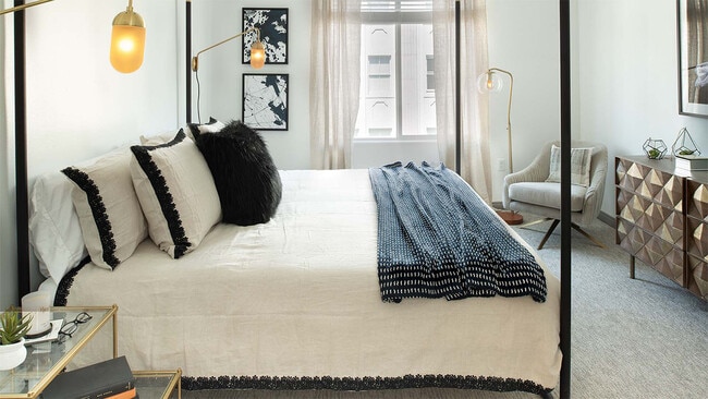 Spacious apartment bedroom with carpeted floors. - Shops on Pine - Bldg P
