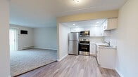 Located at 1599 W Irving Park Rd in Itasca, Illinois, this single-floor unit offers a practical and updated layout designed for comfortable everyday living. The kitchen is a standout feature, outfitted with stainless steel appliances including a refrigerator, electric range, and over-the-range microwave. White shaker-style cabinetry extends to the ceiling, providing ample storage, while light wood-look vinyl flooring and recessed lighting give the space a clean, modern feel. A marble-look countertop and a single-basin sink complete the functional design. The kitchen opens directly to the living area, which transitions to plush carpeting and features a sliding glass door that floods the room with natural light and provides views of the lush greenery outside. The bedrooms are carpeted and feature neutral-toned walls, textured ceilings, and baseboard heating. One bedroom benefits from a bright window with natural light and tree views, while another offers a quiet, enclosed atmosphere. The bathroom is finished with wood-look flooring, a white vanity, a full tub-shower combination with tile surround, and clean chrome fixtures. Throughout the unit, a consistent use of neutral tones and updated finishes creates a cohesive and move-in-ready environment.