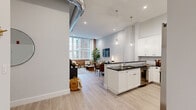 Located at 316 15th Street in Jersey City, NJ, this thoughtfully designed two-bedroom, two-bathroom residence blends modern finishes with industrial-chic character across a single, well-appointed floor. The open-concept kitchen and living area serves as the heart of the home, where the kitchen impresses with crisp white shaker cabinetry, dark granite countertops, a classic subway tile backsplash, stainless steel appliances, and a peninsula with seating — ideal for casual dining or entertaining. The living room is a standout space, bathed in natural light from large grid-pane windows framed by exposed brick and complemented by an open-ceiling duct detail that adds an urban loft quality. The spacious primary bedroom offers mirrored sliding closet doors and a serene, neutral palette, while the second bedroom benefits from its own generous window with natural light. Both bathrooms are finished with large-format marble-look porcelain tile flooring, sage-toned vanities, and clean white countertops. A dedicated walk-in closet with built-in shelving provides ample storage. In-unit laundry adds everyday convenience. Light hardwood-style flooring flows throughout the main living areas, tying the space together with a warm, cohesive aesthetic.