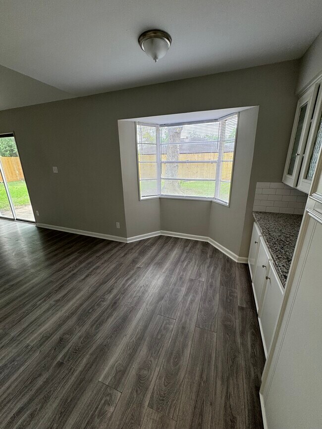 Zona de desayuno soleada con ventanales y vistas al patio trasero. - 11927 Troulon Dr