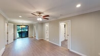 Located at Fairfield Tudor At North Babylon in North Babylon, NY, this single-floor residence combines classic architectural details with contemporary updates throughout. The living areas are defined by light hardwood-style flooring, soft sage-toned walls, and crisp white crown molding that runs consistently through each room, creating a cohesive and polished aesthetic. Ceiling fans with integrated lighting fixtures are installed in the main living spaces, contributing to both comfort and visual continuity.

The kitchen is thoughtfully designed with white shaker-style cabinetry, stainless steel appliances including a range, over-the-range microwave, and refrigerator, as well as a marble-look countertop and coordinating tile backsplash. A stainless steel sink with a brushed gold faucet adds a refined finishing touch. The kitchen connects openly to the main living area, promoting an efficient and functional layout.

The living and sleeping areas are generously proportioned, with recessed lighting and baseboard heating providing year-round comfort. Natural light enters through windows overlooking greenery, enhancing the overall brightness of the space. The bathroom features a soaking tub with a sliding glass enclosure, white subway tile surround, and a frosted privacy window, offering a clean and modern finish throughout.