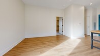 This contemporary 560 square foot apartment offers a thoughtfully designed living space on a single floor. The open-concept layout seamlessly integrates the kitchen, living, and dining areas, creating a sense of spaciousness. The kitchen is a highlight, featuring white cabinetry, stainless steel appliances, and a substantial island with a butcher block top, ideal for meal preparation or casual dining.

Throughout the apartment, warm wood flooring adds a touch of natural elegance, contrasting beautifully with the crisp white walls. The bedroom, measuring 170 square feet, provides ample space and is carpeted for comfort. Large windows in both the living area and bedroom flood the space with natural light and offer views of the surrounding area.

The bathroom is modern and functional, with a white vanity, ample storage, and a shower/tub combination. Recessed lighting throughout the apartment adds to the contemporary feel. The overall design prioritizes efficiency and style, making excellent use of the available square footage to create a comfortable and inviting living environment.