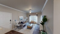 Located in Mansfield, TX, this single-story residence at 1601 Towne Crossing Blvd offers a thoughtfully designed layout with modern finishes and a warm, inviting ambiance throughout. The living room serves as the heart of the home, showcasing crown molding, wood-style flooring, and large windows with blinds and drapes that allow abundant natural light to filter in. A comfortable seating arrangement anchors the space alongside a glass-top coffee table and tasteful décor.

The kitchen is outfitted with dark cabinetry, stainless steel appliances including a refrigerator, microwave, and range, complemented by light countertops and a double-basin sink set along an extended peninsula — ideal for both cooking and casual dining. Adjacent to the kitchen, a dedicated dining area comfortably seats multiple guests and features wood-style flooring and decorative wall accents.

The bedrooms offer a restful retreat, each with plush carpeting, ceiling fans, generous windows with blinds and curtains, and ample natural light. The bathroom is finished with dark wood-tone vanity cabinetry, a large framed mirror, a shower-tub combination, and wood-style flooring, delivering both function and style. Together, these spaces create a cohesive and comfortable living environment.