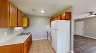 Located in Tallapoosa, GA, this single-story, 2-bedroom, 1-bathroom home offers a practical and comfortable layout finished with consistent design choices throughout. The living room is a bright, open space enhanced by large windows that allow ample natural light to fill the room, complemented by wood-look laminate flooring and a ceiling fan overhead. Adjacent to the living area, the kitchen features warm honey-toned wood cabinetry, light countertops, a double-basin sink, and white appliances including a range and refrigerator, all set atop classic tile flooring.

The primary bedroom is a well-proportioned room with wood-look flooring, a ceiling fan, and access to a walk-in closet. The second bedroom mirrors the same neutral palette and flooring, with a ceiling fan and a window that brings in natural light. Both bedrooms are finished with clean white trim and six-panel doors.

The bathroom is equipped with a single-sink vanity featuring wood cabinetry, a tub-shower combination, tile flooring, and a window for natural ventilation. Throughout the home, neutral gray-beige walls and textured ceilings create a cohesive and understated aesthetic, making this a well-maintained and move-in ready residence.