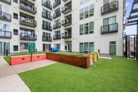 Courtyard with artificial turf, seating, and building balconies.