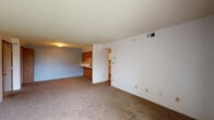 Located at 386 Parkers Mill Rd in Somerset, Kentucky, this single-floor unit offers a practical and functional layout spread across several well-defined living spaces. The open living area is generously sized, featuring wall-to-wall carpeting, a textured ceiling, and a pass-through connection to the kitchen, creating an easy flow between the main living and cooking areas. Neutral wall tones and overhead ventilation contribute to a clean, understated atmosphere throughout.

The galley-style kitchen is efficiently designed with ample white cabinetry featuring wood-trimmed accents, generous countertop space, a stainless sink, and a full-size refrigerator. Light tile flooring runs through the kitchen, providing a practical contrast to the carpeted areas elsewhere in the unit.

The bedrooms are carpeted and well-proportioned, each featuring ceiling fans with integrated lighting and windows that bring in natural light. One bedroom includes a double-door closet with built-in hanging rod, offering useful storage capacity.

The bathroom is spacious and tile-floored, equipped with a wide vanity featuring wood-trimmed cabinetry, a toilet, and a separate shower area. Warm wood-toned door trim and accents are found consistently throughout the unit, lending a cohesive and traditional character to the overall interior.