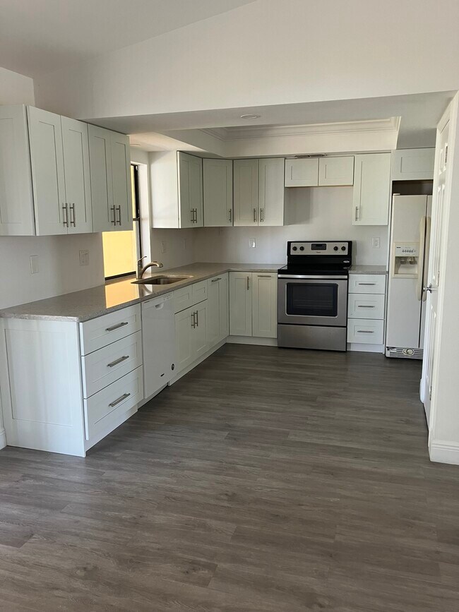 Open kitchen with modified ceiling and lights of canned lighting in kitchen and dining areas. - 3231 SW 1st Pl