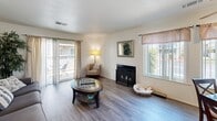 This well-appointed 2-bedroom, 1-bathroom single-story home in Hanford, California offers a comfortable and functional layout designed to maximize everyday living. The living room serves as the heart of the home, featuring wood-style flooring, a classic fireplace, and sliding glass doors that open to a private patio, filling the space with natural light and providing seamless indoor-outdoor access. Multiple windows enhance the bright, open feel throughout.

The kitchen is a standout feature, boasting rich dark wood cabinetry, light countertops, a center island for additional prep space, recessed lighting, and a full suite of black appliances including a range, dishwasher, and microwave. A double-basin sink sits beneath a window overlooking the exterior.

The primary bedroom is generously sized, offering plush carpeting, a sliding door closet, and a window that allows for natural light. The second bedroom also features soft carpeting, a large sliding closet, and its own window. Both rooms provide comfortable, quiet retreats.

The bathroom is clean and functional, featuring a full tub-shower combination with updated fixtures. Throughout the home, a neutral color palette and consistent finishes create a cohesive, inviting atmosphere well-suited for a variety of lifestyles.