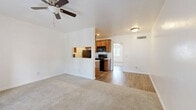 Located at 1111 W Saint Mary's Rd in Tucson, Arizona, this single-floor, one-bedroom, two-bathroom residence offers a well-organized and functional layout. The combined living, dining, and kitchen area forms the heart of the home, featuring a seamless transition between carpet and wood-look flooring. A ceiling fan anchors the living space, which benefits from a bright, open feel and a pass-through window connecting to the kitchen. The galley-style kitchen is well-equipped with warm wood cabinetry, marble-patterned countertops, a stainless sink, and black appliances including a range, microwave, and refrigerator — all efficiently arranged for easy use. The bedroom is a comfortable, carpeted retreat featuring a ceiling fan, a closet, and a standout set of French doors that open to the outdoors, flooding the room with natural light. Two bathrooms serve the unit, with one featuring a full tub-shower combo, providing added convenience. Two closets offer practical storage throughout. Clean white walls, consistent trim work, and a neutral color palette lend the space a bright, move-in-ready character throughout.