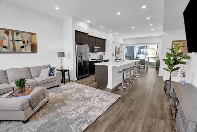 Open floor plan living room with large center island and lots of light. - 279 W 8th St