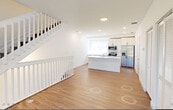 This contemporary three-story townhouse in Palmetto Bay, Florida offers a well-organized layout across three distinct levels. The ground floor houses a spacious private garage with an automatic opener and an electrical panel, along with a utility room for added convenience. The main living level features a bright, open-plan kitchen and living room with rich hardwood-style flooring, large sliding glass doors leading to a balcony, and abundant natural light framed by clean white walls. The kitchen is outfitted with white shaker cabinetry, stone countertops, stainless steel appliances, and a decorative window that adds a artistic touch. A staircase with white balusters connects all three levels seamlessly. The upper floor hosts three well-proportioned bedrooms, each featuring hardwood-style flooring and roller shades. The primary bedroom is distinguished by a tray ceiling with recessed lighting and a ceiling fan. All four bathrooms are finished in neutral tones, with at least one featuring a glass-enclosed walk-in shower and stone countertops. Ample storage is provided through four closets fitted with wire shelving systems, plus a pantry and a dedicated laundry area. The home's consistent white palette, modern fixtures, and thoughtful layout create a clean, move-in ready living environment.