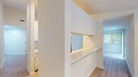 Located at 140 W Crescent Square Dr in Graham, NC, this single-story residence presents a clean, modern interior finished in a neutral white palette throughout. The layout is thoughtfully organized, with distinct living, kitchen, and bedroom areas connected by light wood-look flooring in the main living spaces.

The kitchen is equipped with stainless steel appliances, including an electric range, over-the-range microwave, and refrigerator, all complemented by white cabinetry with matte black hardware and light countertops. A pass-through window with a counter ledge connects the kitchen to the adjacent living or dining area, promoting an open, communicative flow between spaces.

The main living area features light wood-look flooring and a ceiling fan with integrated lighting, while large windows fitted with blinds allow natural light to fill the room. Additional rooms include multiple carpeted bedrooms, each with windows offering outdoor views of surrounding greenery. One room features light wood flooring and track lighting.

The bathroom includes a full tub-shower combination with chrome fixtures. A separate area reveals access to a walk-in closet outfitted with a clothing rod, conveniently positioned alongside a vanity with cabinet storage. The overall ambiance is bright, clean, and move-in ready.