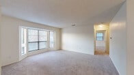 Located at 2401 Lakeview Rd in North Little Rock, AR, this well-appointed one-bedroom, one-bathroom residence offers a thoughtfully designed single-floor layout. The expansive living room is a standout feature, highlighted by large bay windows that fill the space with natural light and soft neutral carpeting that extends throughout the common areas. A pendant light anchors the adjoining dining area, which flows seamlessly into the galley-style kitchen. The kitchen is equipped with warm wood cabinetry, ample counter space, stainless steel appliances including a refrigerator and dishwasher, and durable hardwood-style flooring. The generously sized bedroom features a ceiling fan with light fixture, a window with natural light, and convenient access to multiple closets — four in total throughout the unit — providing exceptional storage. The bathroom is finished with a full soaking tub and tiled surround in a neutral stone-look pattern, lending a clean and polished aesthetic. Additional functional spaces include a dedicated laundry room, utility room, and a connecting hallway. A textured ceiling detail is present throughout, adding subtle architectural character to this comfortable and practical North Little Rock home.