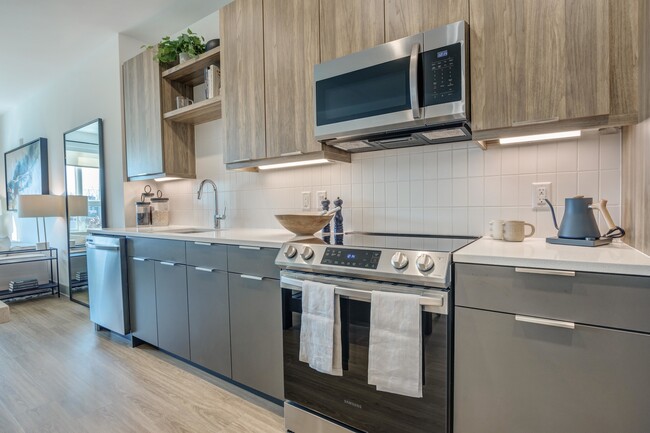 Enjoy a kitchen decked out with gorgeous quartz countertops, custom cabinetry, pendant lighting and Energy Star stainless-steel appliances. - Modera Woodbridge