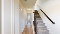 Located at 780 Bassett Dr in Chambersburg, PA, this three-story home offers five bedrooms, two full bathrooms, and a well-organized layout spread across three distinct levels. The main living floor features a combined dining and living area brightened by natural light and accented with a classic chandelier, alongside a fully equipped kitchen showcasing rich dark-wood cabinetry, granite countertops, and stainless steel appliances including a refrigerator, range, and over-the-range microwave — all set atop light hardwood-style flooring. The hallways are clean and bright, with wood-toned flooring and carpeted staircases finished with dark wood banisters providing easy access between floors. Bedrooms offer a mix of light hardwood-style and plush carpet flooring, with several rooms featuring natural light through blinds-covered windows. Select bedrooms include built-in closets for added storage convenience. Both bathrooms are well-appointed with granite-topped vanities featuring dark wood cabinetry, tub-shower combinations, and clean white finishes. A dedicated laundry room houses a full-size washer and dryer with wire shelving above. The home's neutral color palette and consistent finishes throughout create a cohesive and functional living environment.