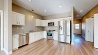 Located at 4340 Belden Greens Cir NW in Canton, Ohio, this single-story home offers a thoughtfully designed layout with three bedrooms, two bathrooms, and a cohesive modern aesthetic. Light wood-style flooring flows through the main living areas, hallway, and kitchen, while soft neutral tones on the walls create a bright, welcoming atmosphere throughout.

The kitchen is well-equipped with white shaker-style cabinetry, granite-look countertops, and a full suite of stainless steel appliances, including a French door refrigerator, range, built-in microwave, and dishwasher. Recessed lighting and a pendant fixture add warmth to the space.

The living room is generously sized, bathed in natural light through a large window and sliding glass door that opens to an outdoor view, extending the sense of space considerably.

The bedrooms feature plush carpeting and include closets with built-in hanging rods for storage. The bathrooms are finished with white cabinetry, granite-look countertops, and wood-look tile flooring. A central hallway with recessed lighting connects the rooms efficiently, completing this clean, move-in-ready home.