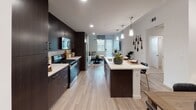 Located at 4868 Cypress St in Montclair, California, this single-story residence showcases a thoughtfully designed open-concept floor plan with contemporary finishes and a cohesive modern aesthetic throughout. Light wood-tone flooring flows seamlessly through the main living areas, creating a warm and inviting atmosphere.

The kitchen is a standout feature, offering dark espresso cabinetry that extends to the ceiling for ample storage, crisp white quartz countertops, a classic subway tile backsplash, and a full suite of stainless steel appliances including a gas range and built-in microwave. A centrally positioned kitchen island with pendant lighting above provides both additional prep space and a casual dining area, while opening directly to the living and dining spaces.

The living area is anchored by a boldly patterned accent wall with geometric wallcovering, lending artistic character to the space. Natural light filters in through large windows dressed with blinds and curtains.

The bedrooms are comfortably appointed with plush carpeting, generous window arrangements that invite natural light, and tasteful design details. The bathroom is clean and well-finished, featuring wood-look tile flooring, a full soaking tub with shower, and a dark wood vanity with a white countertop, completing the residence's consistent modern design language.