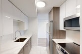 Located at 10025 115 St NW in Edmonton, Alberta, this well-appointed one-bedroom, one-bathroom unit offers a clean, modern aesthetic across a thoughtfully organized single floor. Light-toned hardwood-style flooring runs throughout, lending warmth and continuity to every room.

The living area is generously proportioned, featuring crisp white walls, a textured ceiling, and a large sliding window that frames views of the surrounding Edmonton cityscape, filling the space with abundant natural light. Baseboard heating runs along the perimeter, ensuring comfort throughout the seasons.

The bedroom is a comfortable size, highlighted by a full mirrored sliding-door closet that adds depth and reflects natural light. A window provides additional brightness, and the light flooring continues seamlessly from the rest of the unit.

The bathroom has been finished to a high standard, featuring large-format white marble-style tiles on both the floor and the tub surround. The clean white vanity, soaker tub with shower, and polished chrome fixtures combine to create a sleek, contemporary feel.

A dedicated closet provides practical storage, rounding out the functional layout. The overall ambiance is bright, airy, and move-in ready, with a neutral palette that offers a versatile canvas for any style of furnishing.