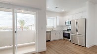 Located at 4288 W Denali Ln in Phoenix, AZ, this two-story home offers a clean, modern design across two well-organized floors. The ground level houses the main living areas, including an open-concept kitchen and living room filled with natural light from large windows and a sliding glass door. The kitchen is appointed with white shaker cabinets, quartz countertops, a white subway tile backsplash, and a full suite of stainless steel appliances. Light wood-tone flooring runs throughout, complementing the crisp white walls and recessed lighting. The ground floor also includes an attached garage with an in-unit water heater, offering practical utility space. A staircase with warm wood-toned treads and a white railing leads to the upper level, where both bedrooms are located. The generously sized primary bedroom features a ceiling fan, recessed lighting, and access to natural light through a window with exterior views. A dedicated laundry area on the upper level includes a full-size washer and dryer. The home includes three bathrooms and two closets distributed across both floors, ensuring ample storage. The overall ambiance is bright, clean, and move-in ready, reflecting a contemporary aesthetic well-suited to the Phoenix lifestyle.