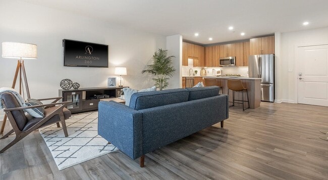 The sofa faces the screen with the kitchen open across the back of the room. - Arlington 360