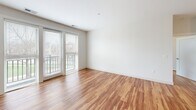 Located at 515-555 Roger Williams Ave in Highland Park, IL, this one-bedroom, one-bathroom residence offers a thoughtfully designed open-concept layout that maximizes functionality and flow. Rich hardwood flooring runs throughout the entire space, lending warmth and continuity to every room.

The kitchen is a standout feature, showcasing dark espresso cabinetry that extends to the ceiling for ample storage, light quartz countertops, a classic subway tile backsplash, and a full suite of stainless steel appliances including a gas range, dishwasher, microwave, and refrigerator. A central island with pendant lighting provides additional prep space and serves as a natural gathering point that connects seamlessly to the living area.

The living room is bright and airy, benefiting from large sliding glass doors that open to a private balcony, inviting natural light and outdoor views into the space. The generously sized primary bedroom also features direct balcony access and a well-proportioned closet. An additional window-facing room offers flexible use as a home office or guest space.

The bathroom is finished with marble-style tile flooring, a dark vanity with a clean white countertop, a large mirror, and a tub-shower combination with tile surround — delivering a crisp, modern aesthetic throughout.