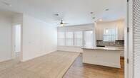 Located at 3030 Greenbusch Rd in Katy, TX, this single-story 2-bedroom, 2-bathroom home offers a thoughtfully designed open-concept layout with clean, modern finishes throughout. The living and kitchen area form the heart of the home, where wood-look flooring transitions seamlessly from the kitchen to carpeted living space. The kitchen is anchored by a granite-topped island with pendant lighting overhead, complemented by light wood cabinetry, a subway tile backsplash, granite countertops, and a stainless steel sink. A ceiling fan and a bank of windows with blinds fill the space with natural light and provide access to the exterior. Both bedrooms feature plush carpet flooring, white walls, and windows with blinds that invite natural light. The primary bedroom is a generous size and includes a spacious walk-in closet with built-in shelving and hanging rods. A second closet offers additional storage. The primary bathroom impresses with a dual-sink vanity featuring granite counters, light wood cabinetry, wood-look flooring, and a glass-enclosed shower with bold dark tile. The secondary bathroom offers a full tub-shower combination with striking large-format dark tile surround and wood-look flooring. A connecting hallway ties all rooms together for a functional and cohesive flow.